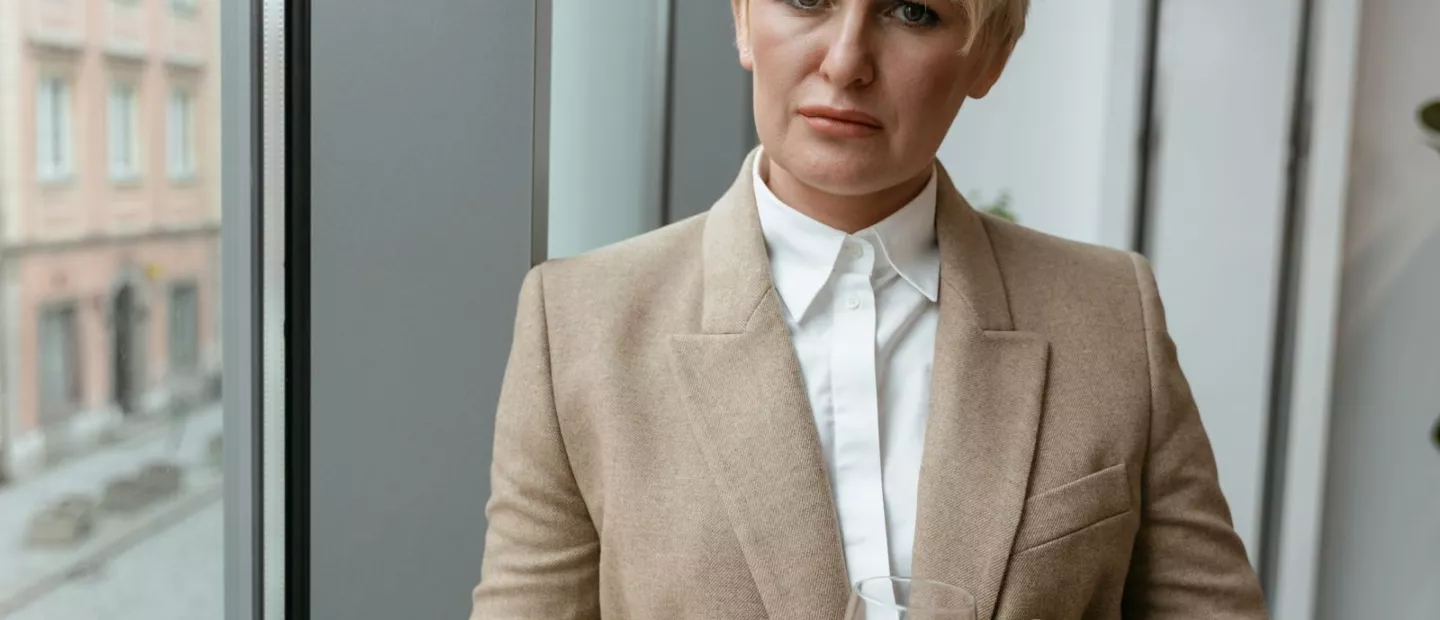 Frau sitzt ruhig mit einem Glas Wasser in der Hand